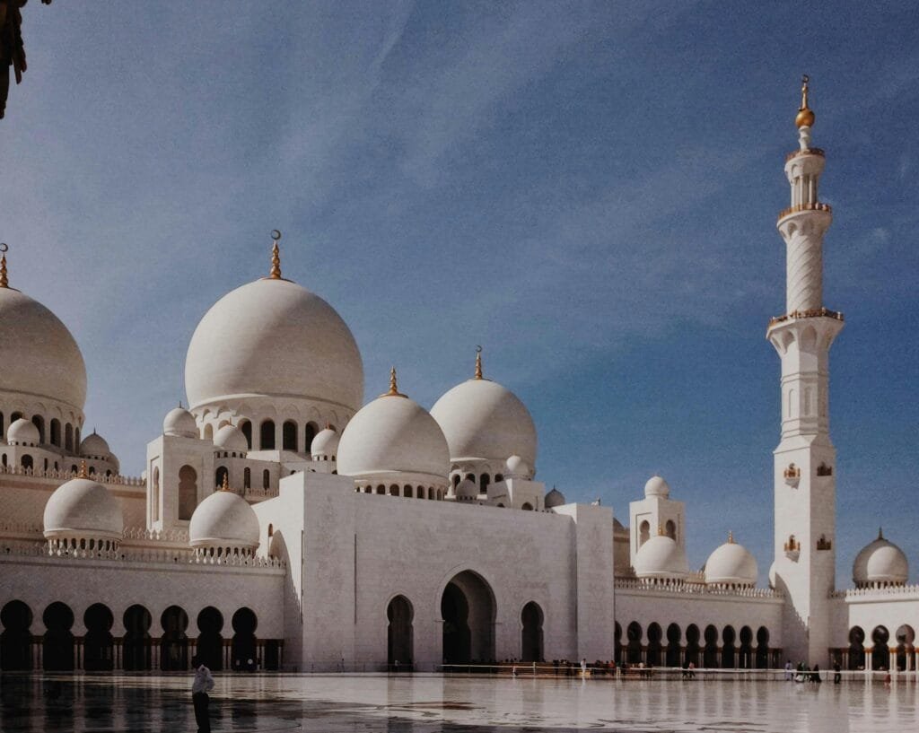Spectacular view of the Sheikh Zayed Grand Mosque in Abu Dhabi, showcasing its stunning domes and elegant minaret under a clear blue sky.