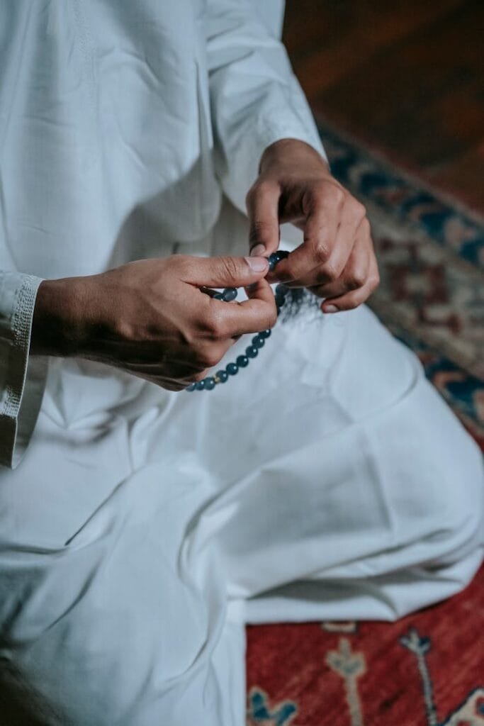 pexels-photo-7129581 A man in traditional attire holding prayer beads, signifying faith and spirituality.