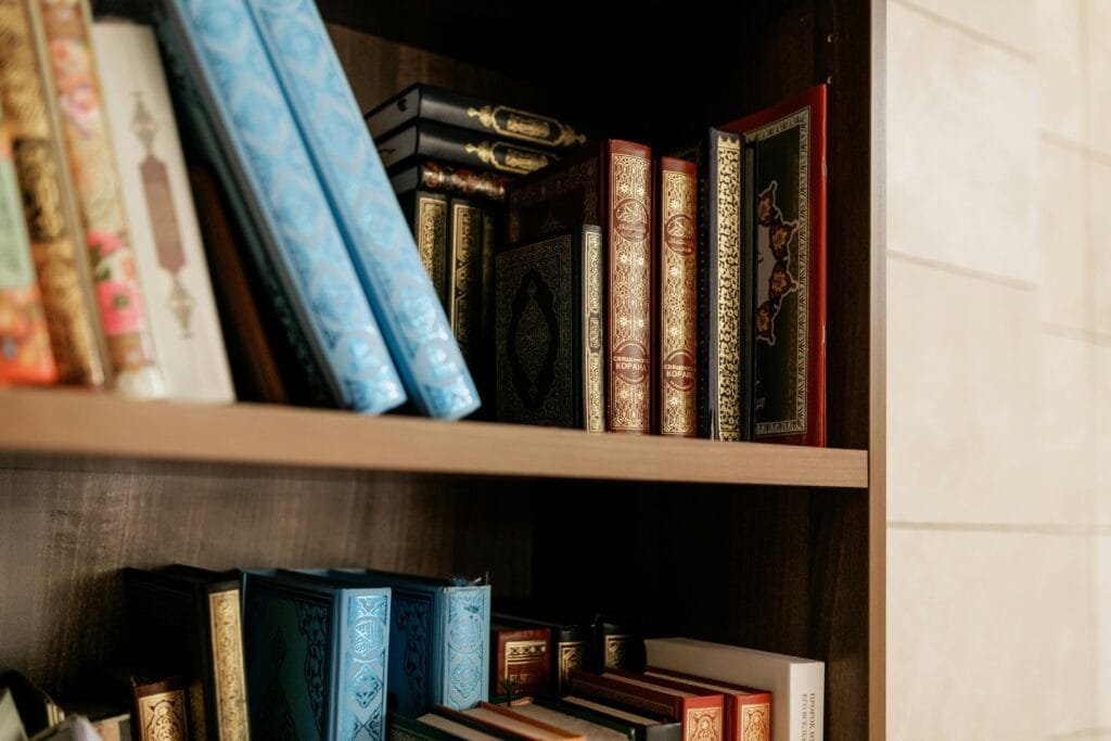 pexels-photo-8164399-8164399 Close-up of decorative Islamic books on a wooden shelf, showcasing intricate bindings.